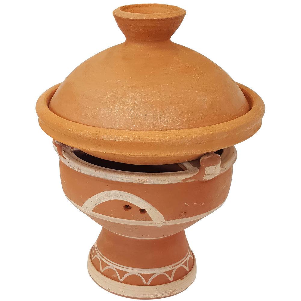 Tajine auf marokkanischem Stövchen aus Ton, mejmar für Holzkohle als Tischgrill für Tagine in Marokko Stil