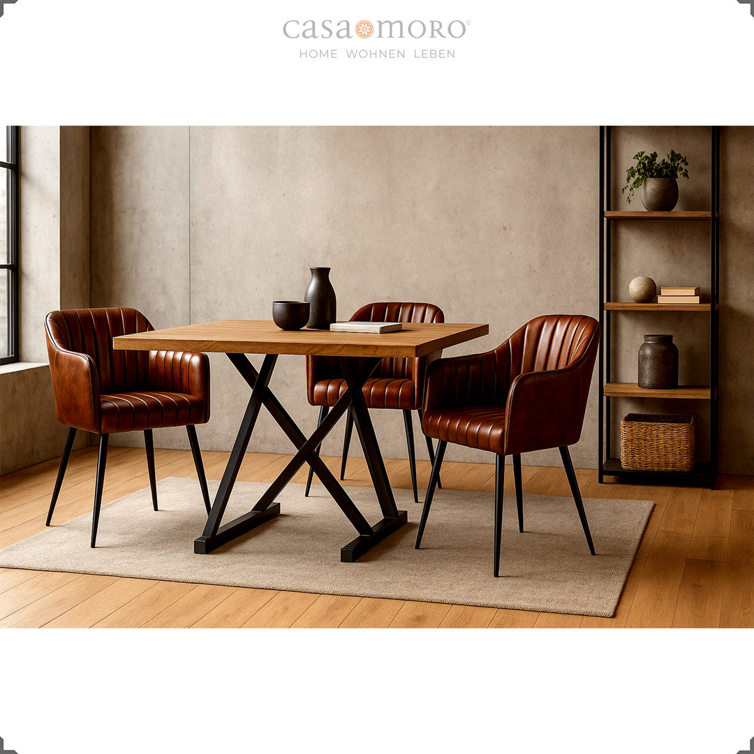 Drei antikbraune Ledersessel mit vertikaler Steppung an einem Holztisch mit schwarzem Metallgestell in modernem Esszimmer mit warmem Licht und minimalistischer Dekoration.