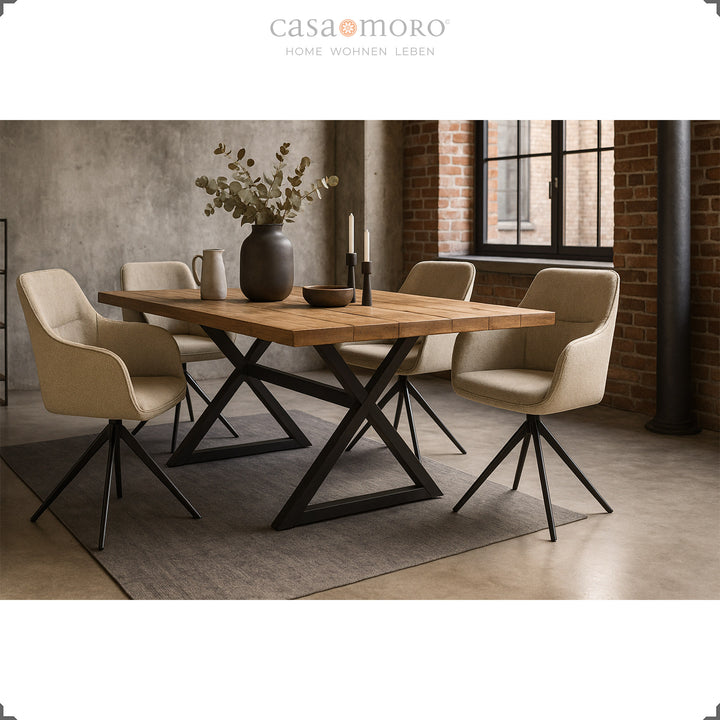 Vier 360° drehbare Polsterstühle mit Armlehnen in Beige an einem Holztisch mit schwarzem Metallgestell in modernem Esszimmer mit Backsteinwand