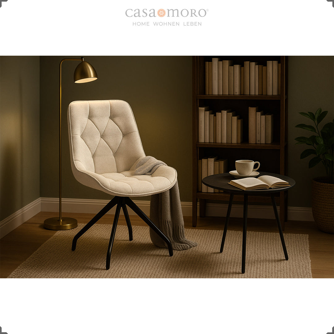 Polsterstuhl 360° drehbar in Beige mit schwarzem Metallgestell – gemütliche Leseecke mit Beistelltisch, Bücherregal und Stehlampe im warmen Licht